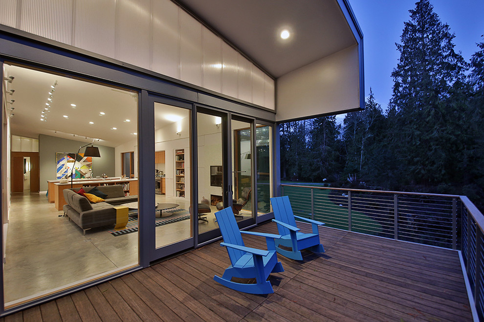 Deck - industrial backyard deck idea in Seattle with a roof extension