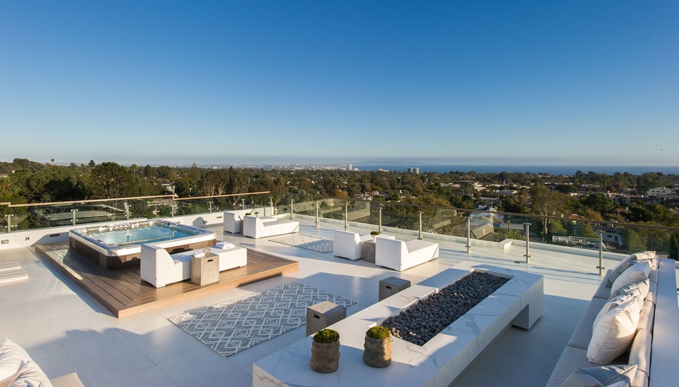 This is an example of an expansive contemporary roof rooftop terrace in Los Angeles with a fire feature and no cover.