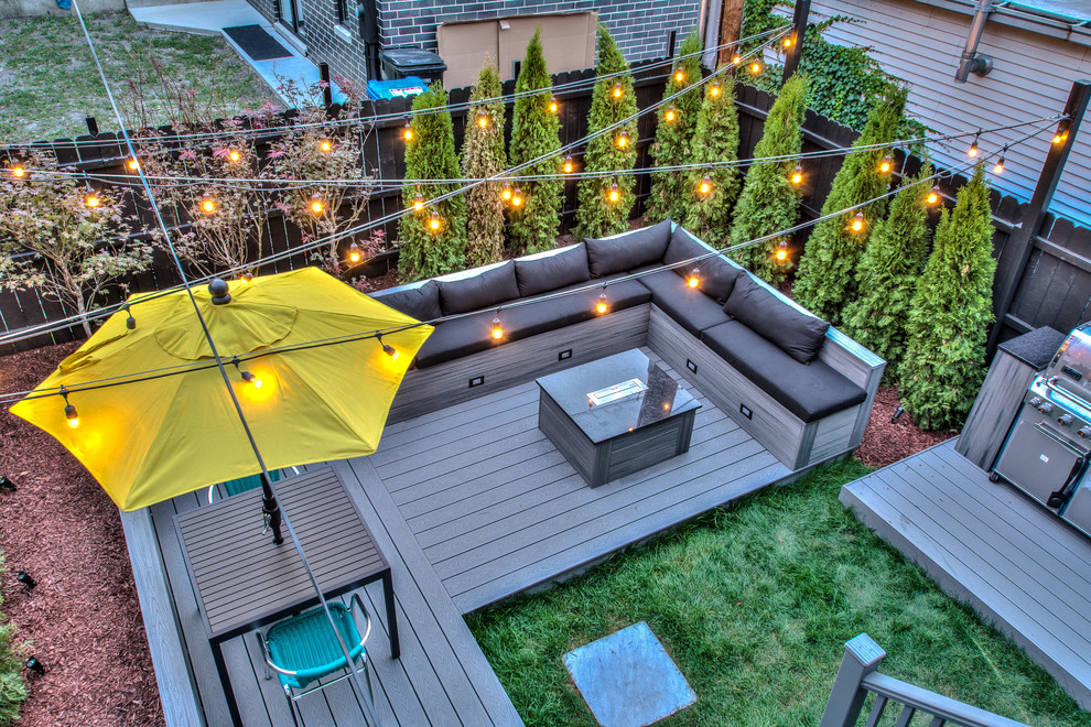 Inspiration for a mid-sized modern backyard deck remodel in Chicago with a fire pit and no cover