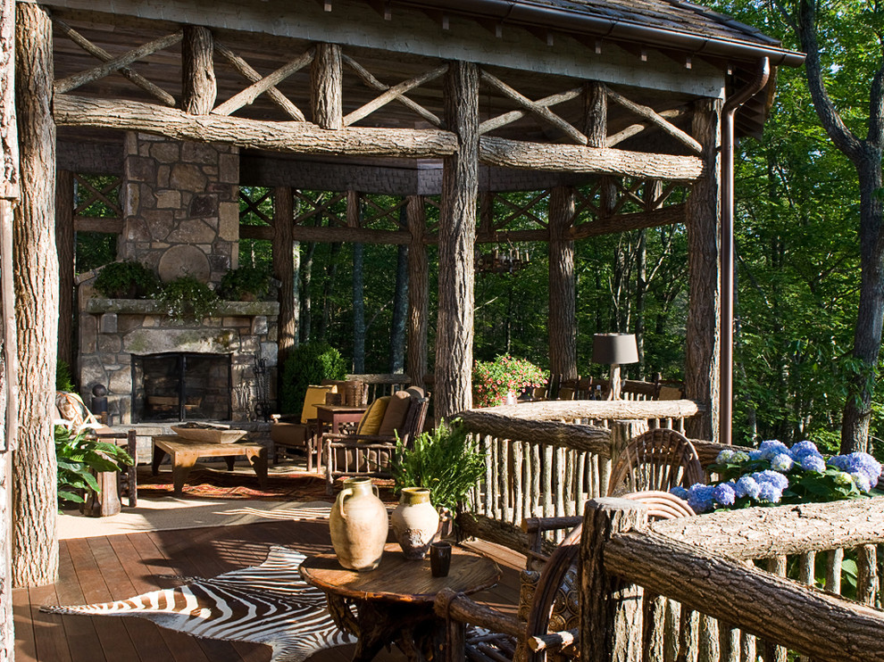 Deck - large rustic backyard deck idea in Atlanta with a roof extension and a fireplace