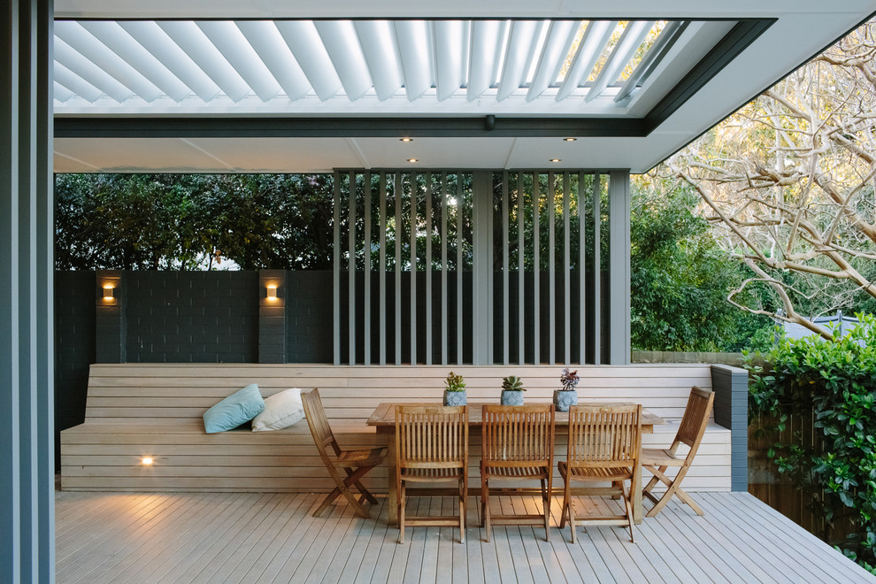 Ejemplo de terraza contemporánea de tamaño medio en patio trasero con pérgola