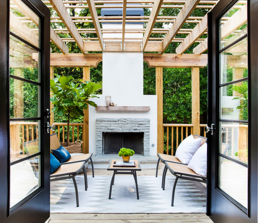 Idée de décoration pour une terrasse arrière tradition de taille moyenne avec un foyer extérieur et une pergola.