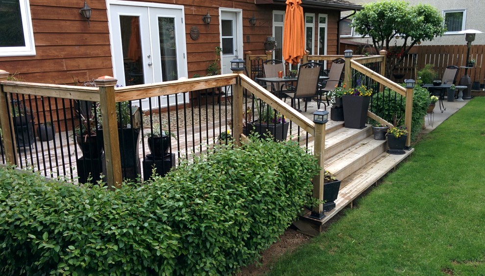 Example of a mid-sized classic backyard deck design in Other with no cover