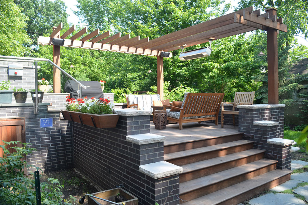 Modelo de terraza tradicional renovada de tamaño medio en patio trasero con brasero y pérgola