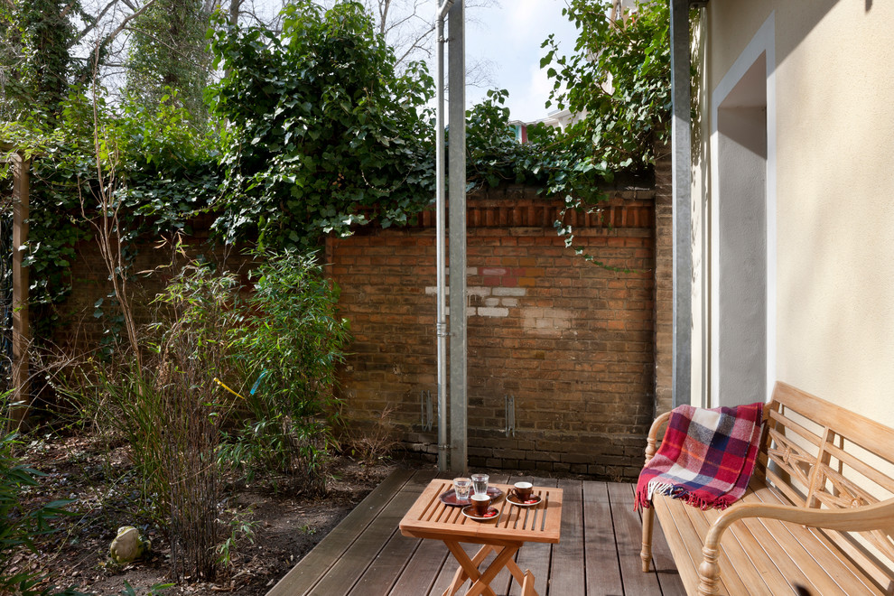 Modelo de terraza exótica pequeña en patio trasero y anexo de casas con jardín vertical