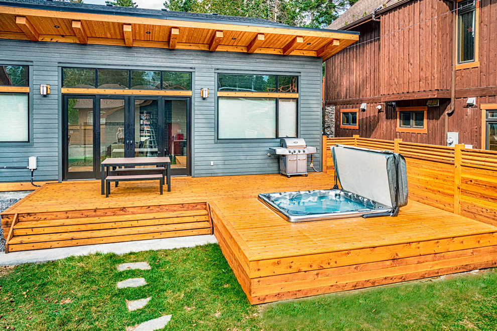Example of a mid-sized mountain style backyard deck design in Calgary