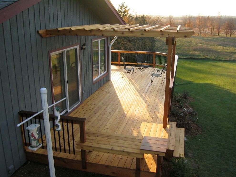 Inspiration for a mid-sized farmhouse side yard deck remodel in Milwaukee with a pergola