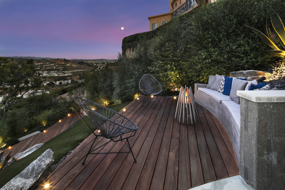 Example of a trendy side yard deck design in Orange County with a fire pit and no cover