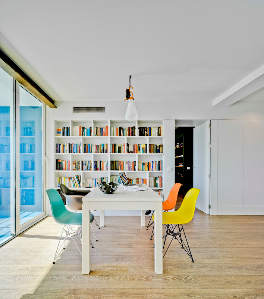 Foto de despacho actual de tamaño medio sin chimenea con paredes blancas, suelo de madera clara y escritorio independiente