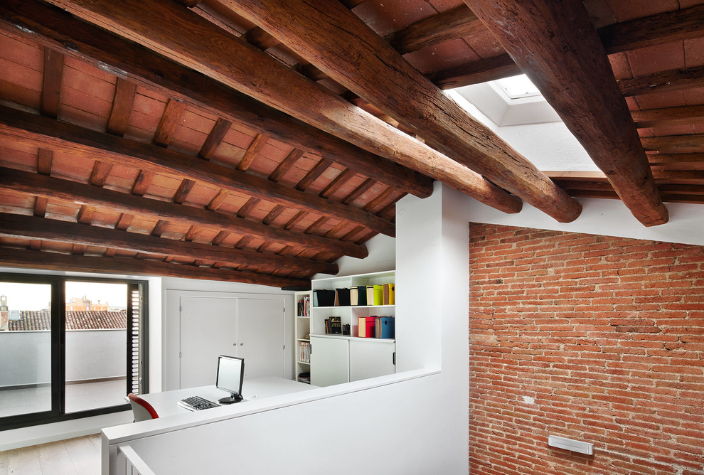 Modelo de despacho industrial de tamaño medio sin chimenea con paredes blancas, suelo de madera clara y escritorio independiente
