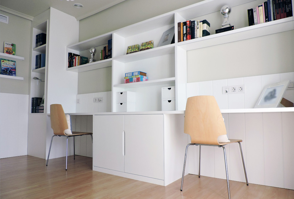 Imagen de estudio escandinavo de tamaño medio con paredes grises, suelo de madera en tonos medios y escritorio empotrado