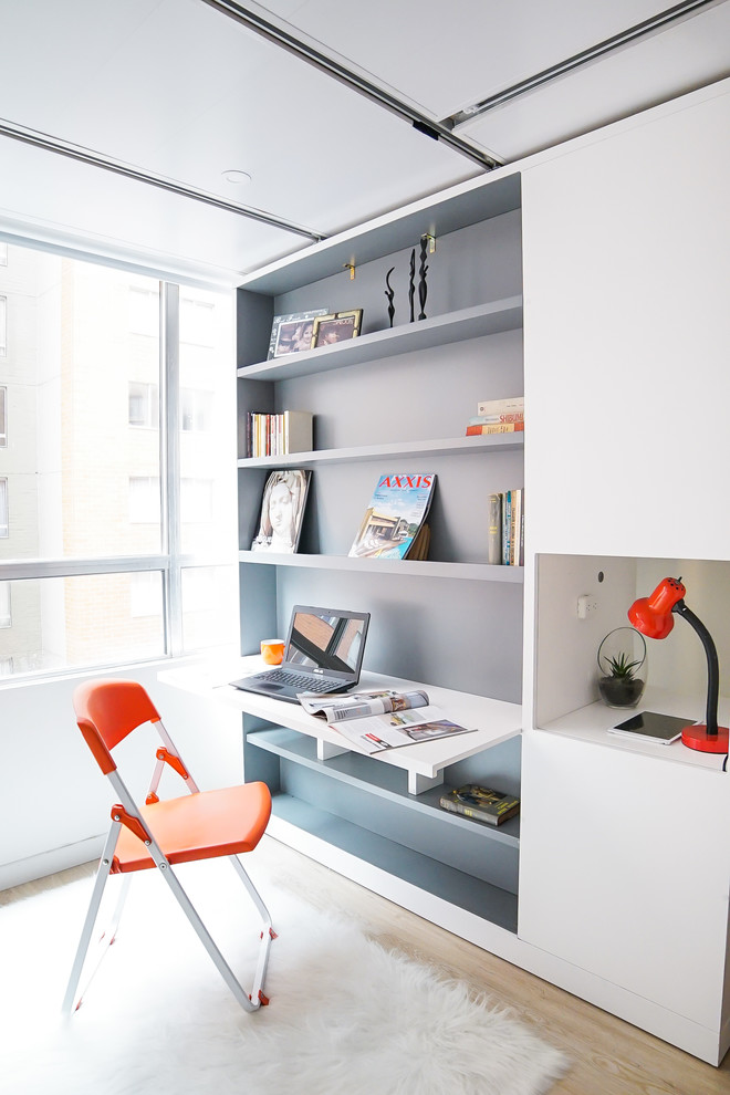 Inspiration pour un petit bureau design avec une bibliothèque ou un coin lecture, un mur blanc, parquet clair, un sol beige et un bureau intégré.