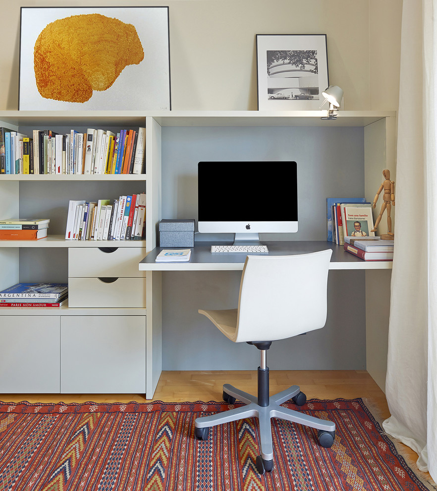 Cette image montre un petit bureau design avec un mur beige, un bureau intégré, un sol en bois brun, un sol orange et aucune cheminée.
