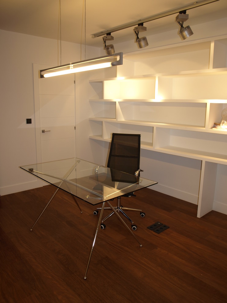 Diseño de despacho actual de tamaño medio sin chimenea con paredes blancas, suelo de madera oscura y escritorio independiente