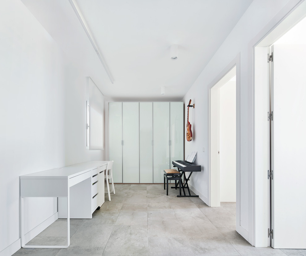 Exemple d'un bureau tendance de type studio avec un mur blanc, un bureau indépendant et un sol gris.