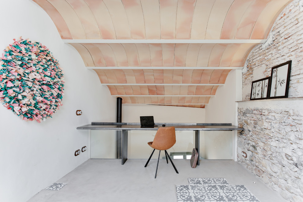 Mittelgroßes Mediterranes Arbeitszimmer ohne Kamin mit Arbeitsplatz, weißer Wandfarbe, Betonboden, Einbau-Schreibtisch und grauem Boden in Sonstige