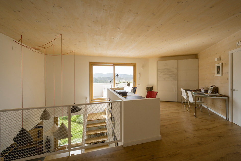 Cette image montre un bureau nordique de taille moyenne avec un mur beige, un sol en bois brun, aucune cheminée, un bureau intégré et un sol marron.