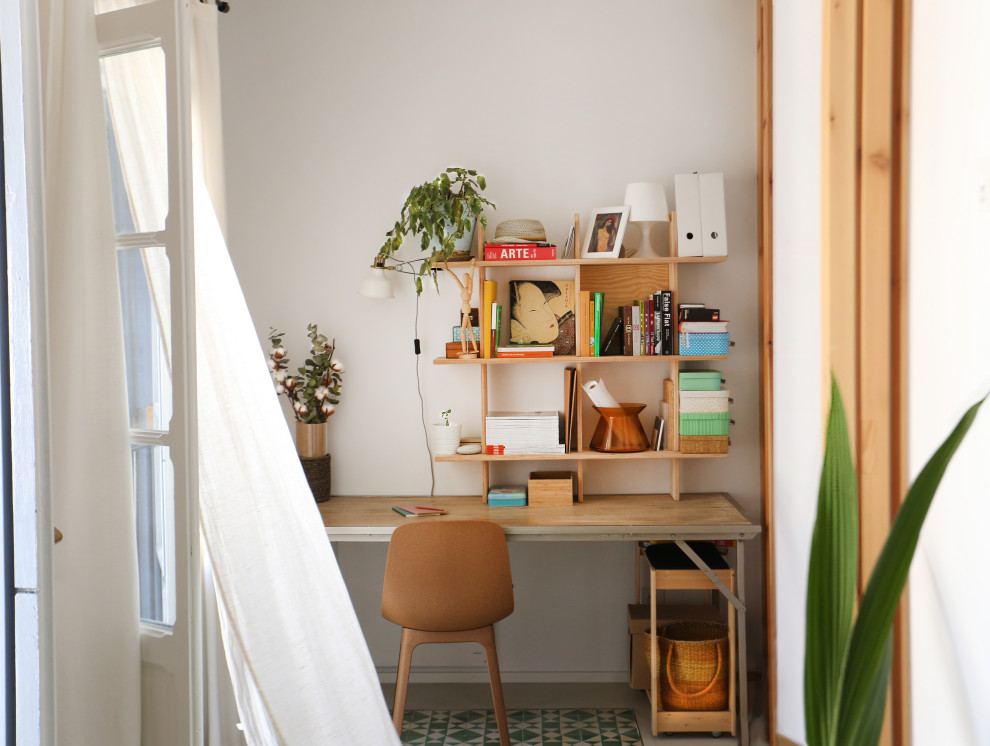 Ispirazione per un piccolo atelier design con pareti bianche, scrivania autoportante e pavimento verde