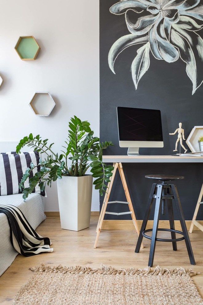 Ejemplo de despacho nórdico con paredes multicolor, suelo de madera clara y escritorio independiente