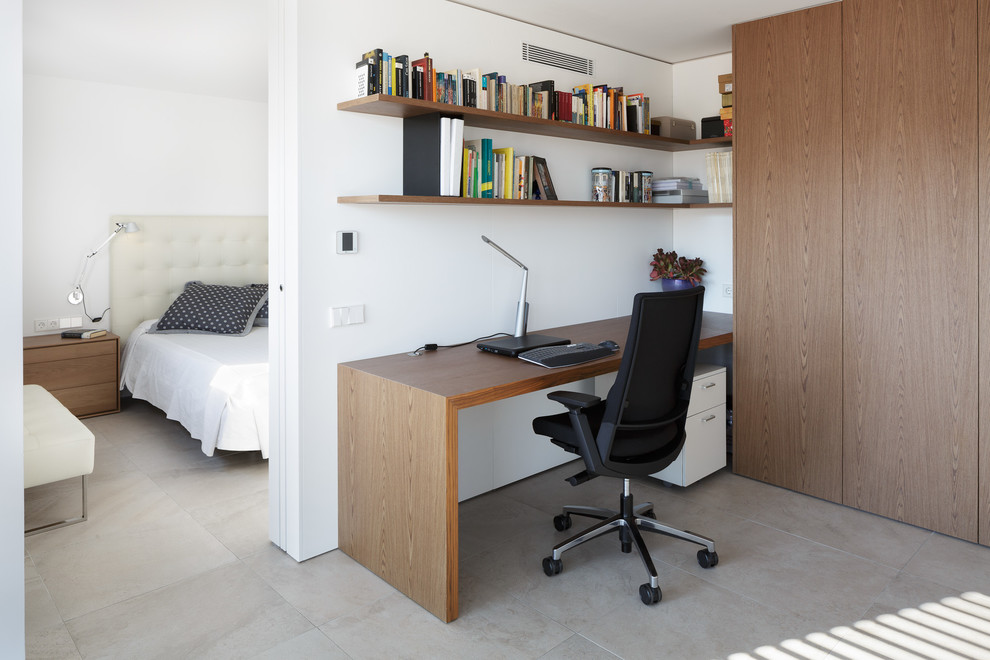 Идея дизайна: рабочее место в современном стиле с белыми стенами, полом из керамогранита, встроенным рабочим столом и серым полом