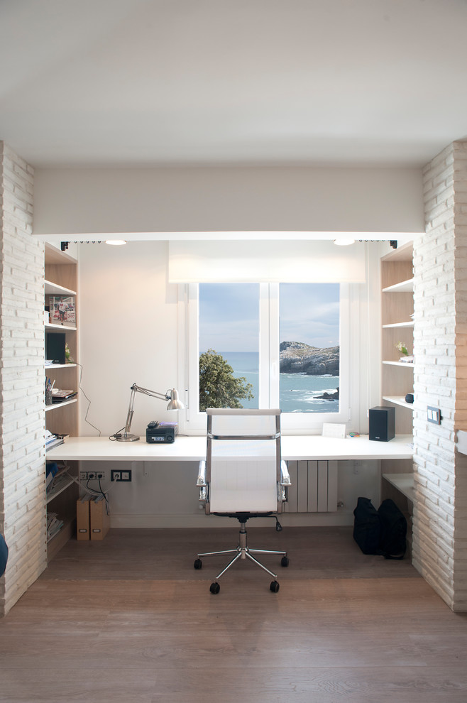 Cette image montre un bureau marin de taille moyenne et de type studio avec un mur blanc, sol en stratifié, aucune cheminée, un bureau intégré et un sol beige.