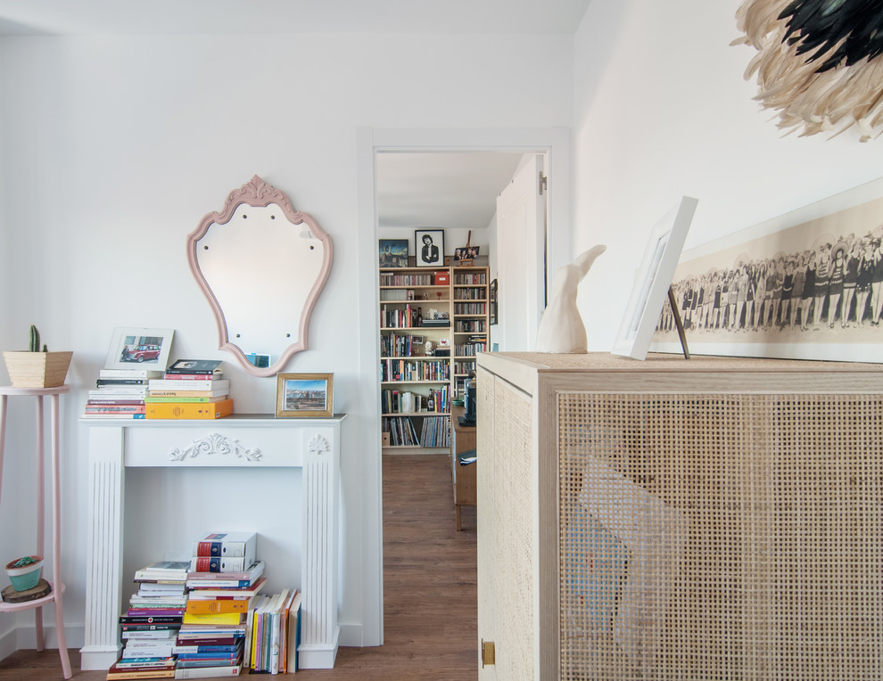 Shabby chic-inspirerad inredning av ett hemmastudio, med vita väggar, mellanmörkt trägolv, ett fristående skrivbord, brunt golv, en standard öppen spis och en spiselkrans i gips