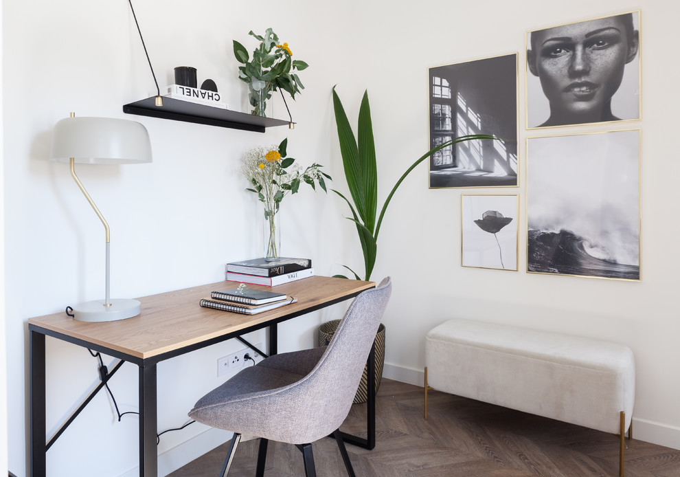 Idee per un atelier nordico di medie dimensioni con pareti bianche, pavimento in laminato, scrivania autoportante e pavimento marrone