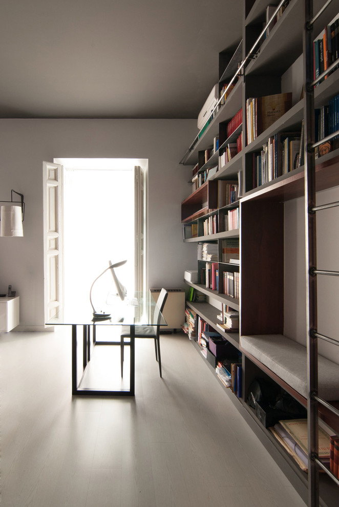 Mittelgroßes Modernes Arbeitszimmer ohne Kamin mit Studio, weißer Wandfarbe, freistehendem Schreibtisch, hellem Holzboden und weißem Boden in Madrid
