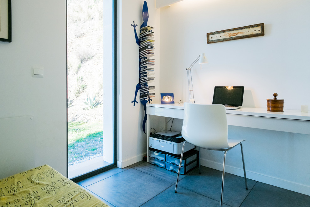 Imagen de despacho mediterráneo pequeño sin chimenea con paredes blancas, suelo de baldosas de cerámica y escritorio independiente