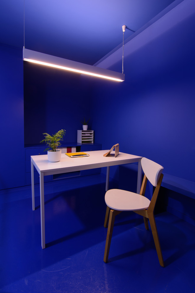 На фото: маленькое рабочее место в стиле модернизм с синими стенами, бетонным полом, отдельно стоящим рабочим столом и синим полом для на участке и в саду с
