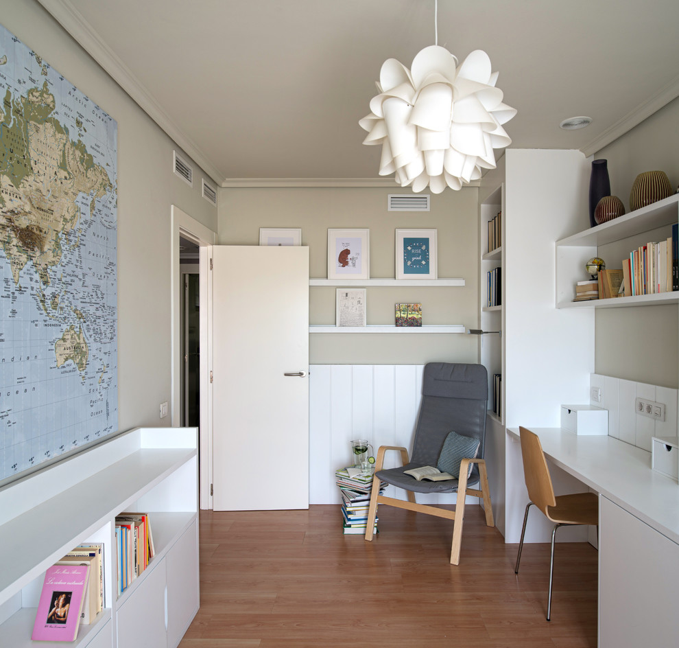 Ispirazione per un atelier minimal di medie dimensioni con pareti beige, pavimento in laminato e scrivania incassata