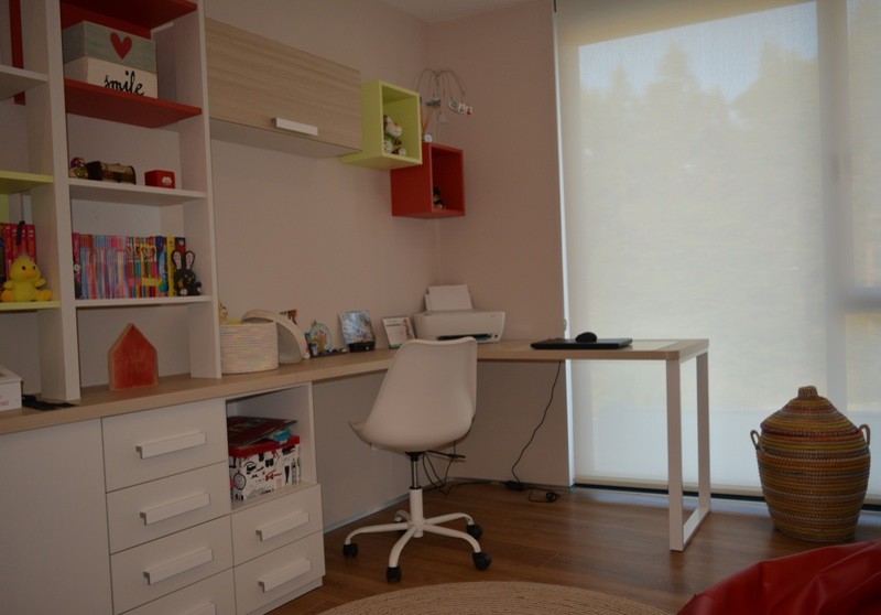 Minimalistisk inredning av ett litet hemmastudio, med beige väggar, ljust trägolv, ett inbyggt skrivbord och beiget golv