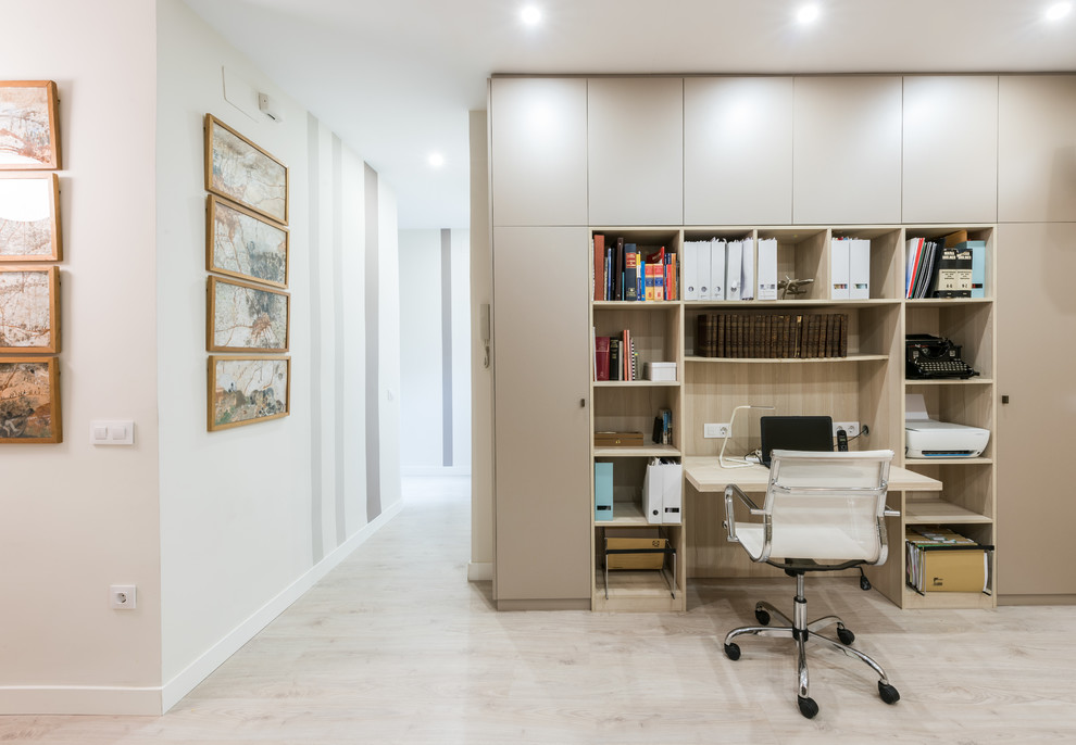 Idee per uno studio minimal con pareti bianche, scrivania incassata e pavimento grigio