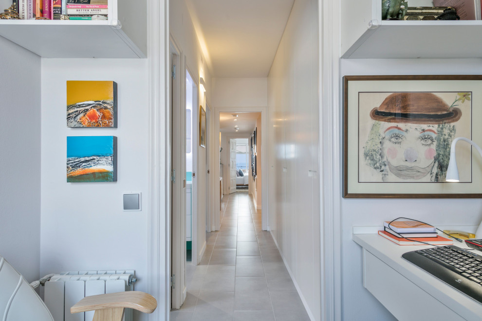 Kleines Eklektisches Arbeitszimmer mit Studio, weißer Wandfarbe, Porzellan-Bodenfliesen, Einbau-Schreibtisch und grauem Boden in Barcelona