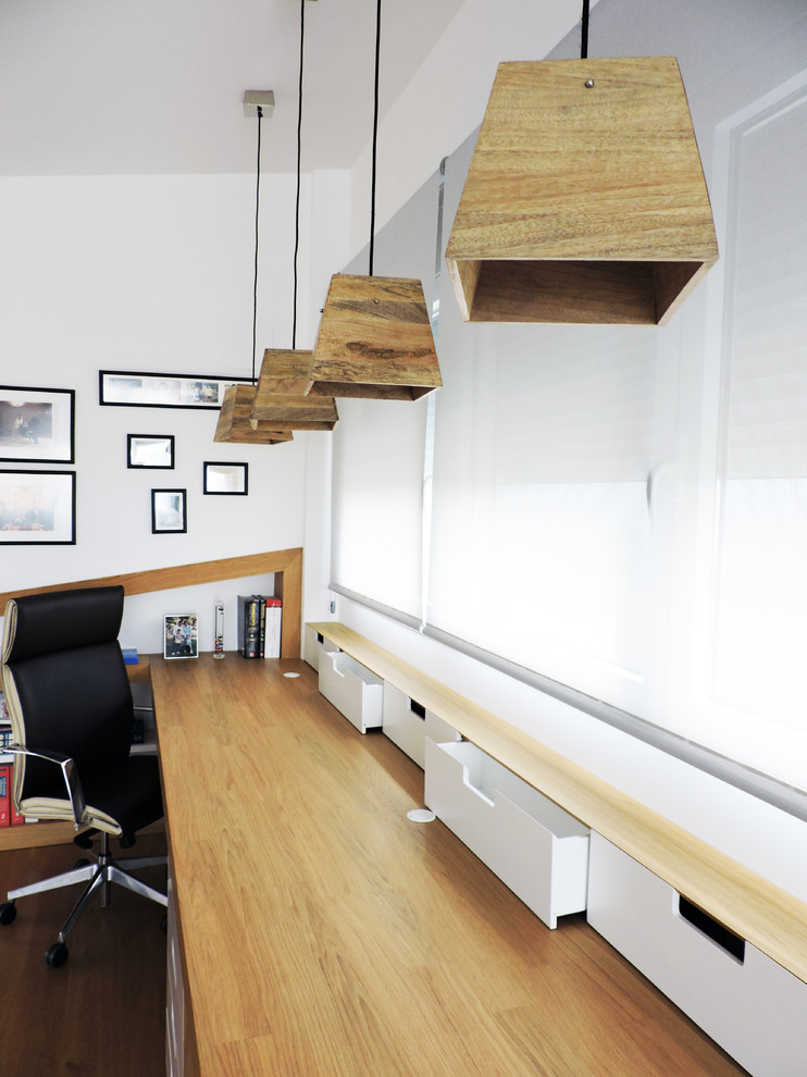 Idee per un ufficio nordico di medie dimensioni con pareti bianche, pavimento in legno massello medio e scrivania incassata