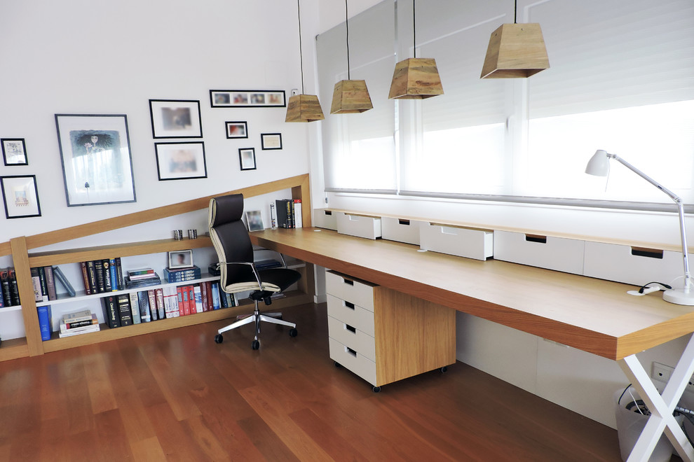 Стильный дизайн: рабочее место среднего размера в скандинавском стиле с белыми стенами, паркетным полом среднего тона и встроенным рабочим столом - последний тренд