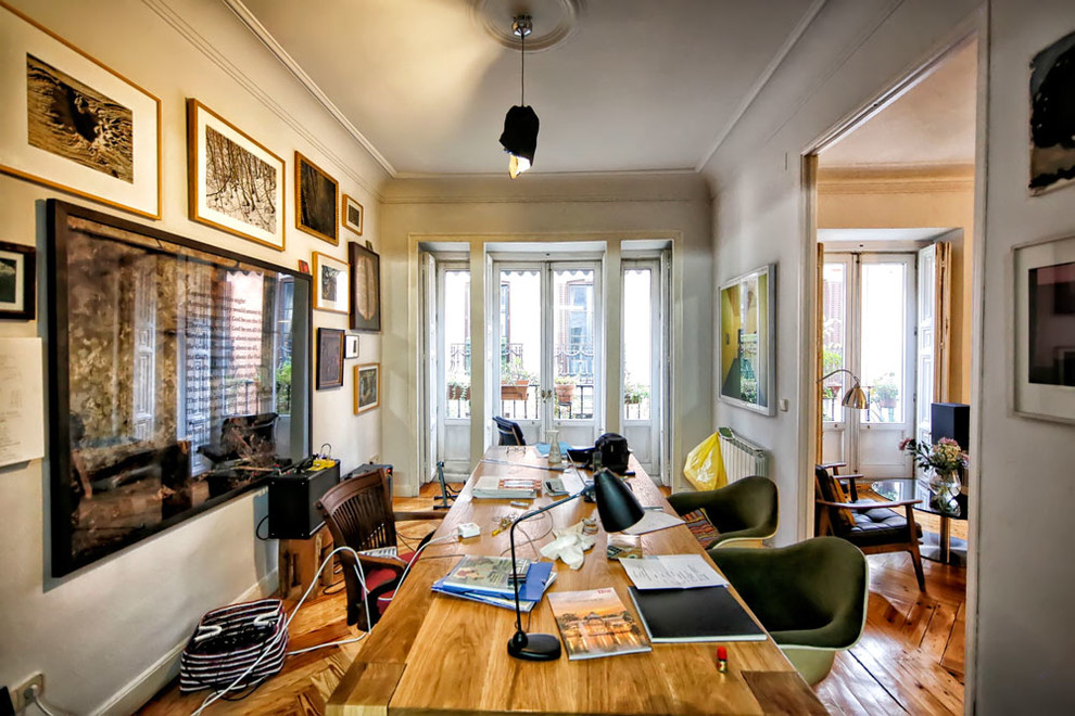 Mittelgroßes Eklektisches Arbeitszimmer ohne Kamin mit Arbeitsplatz, grauer Wandfarbe, braunem Holzboden und freistehendem Schreibtisch in Madrid