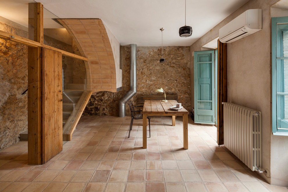 Photo of a large mediterranean study in Barcelona with brown walls, terracotta flooring, no fireplace and a freestanding desk.