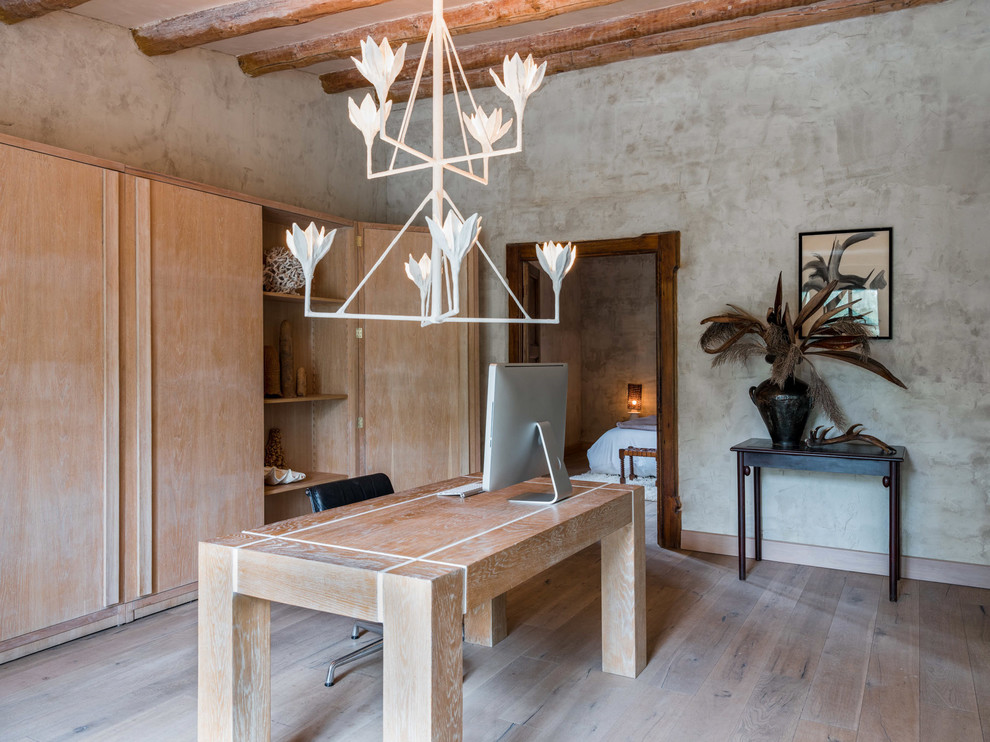 Foto de despacho mediterráneo con paredes grises, suelo de madera clara y escritorio independiente