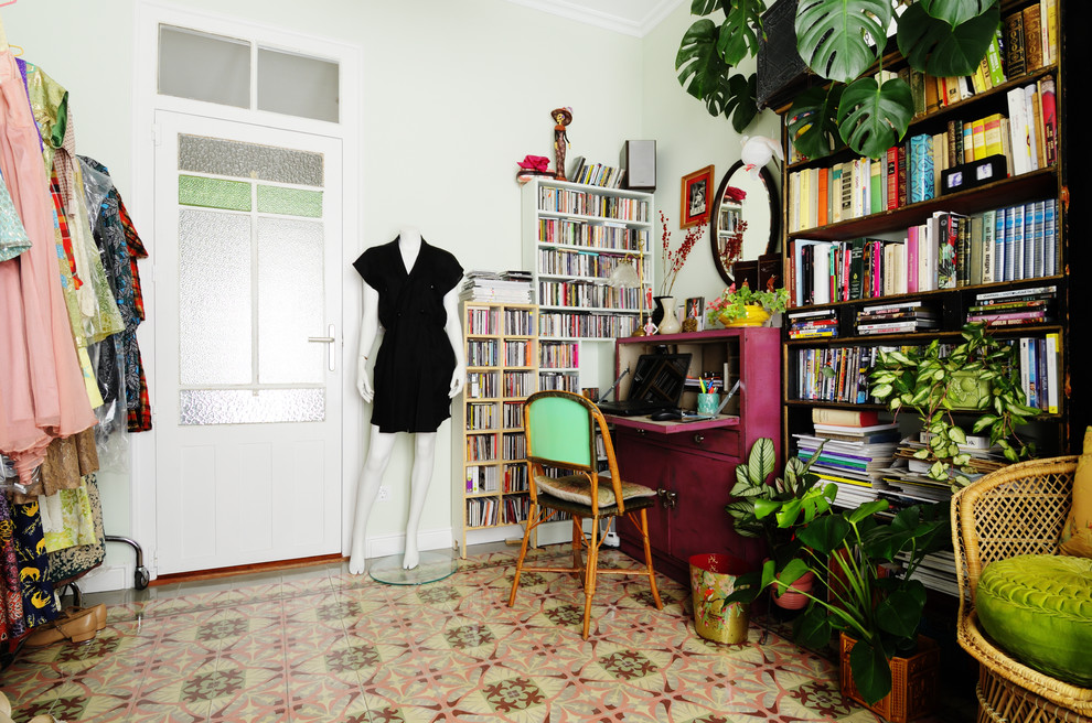 Ispirazione per uno studio boho chic con libreria, pareti verdi, nessun camino, scrivania autoportante e pavimento multicolore