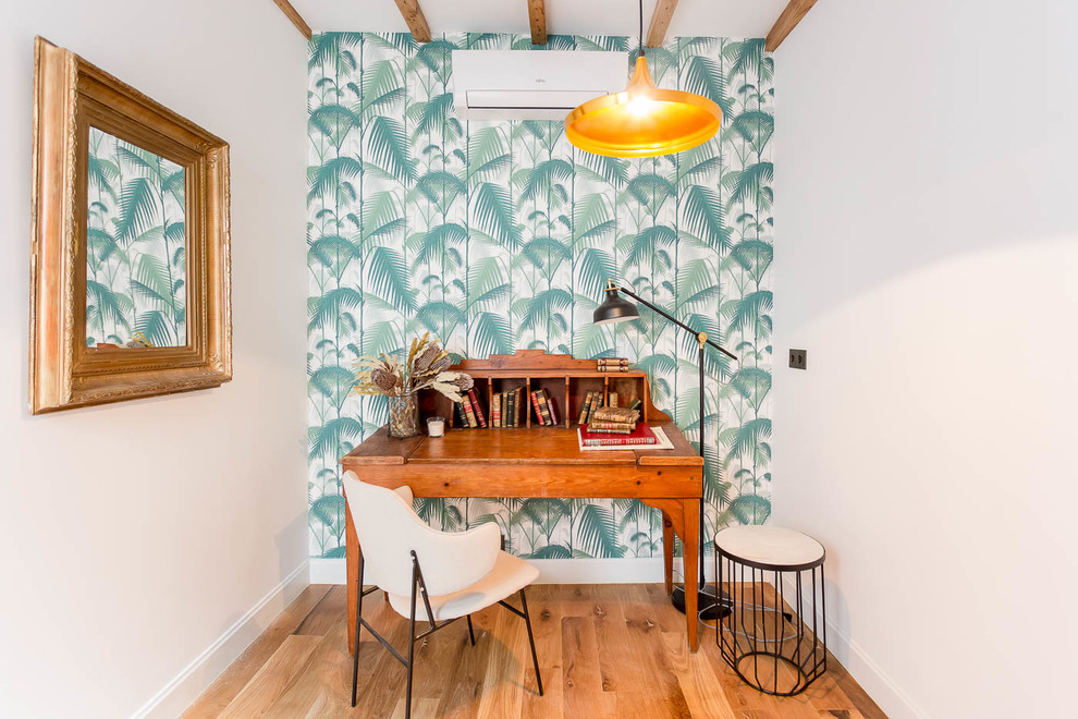 マドリードにある小さなトロピカルスタイルのおしゃれな書斎 (マルチカラーの壁、無垢フローリング、暖炉なし、茶色い床、自立型机) の写真
