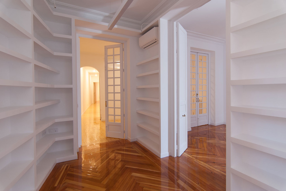 Foto di uno studio classico di medie dimensioni con libreria, pareti bianche, pavimento in legno massello medio, scrivania autoportante e pavimento marrone