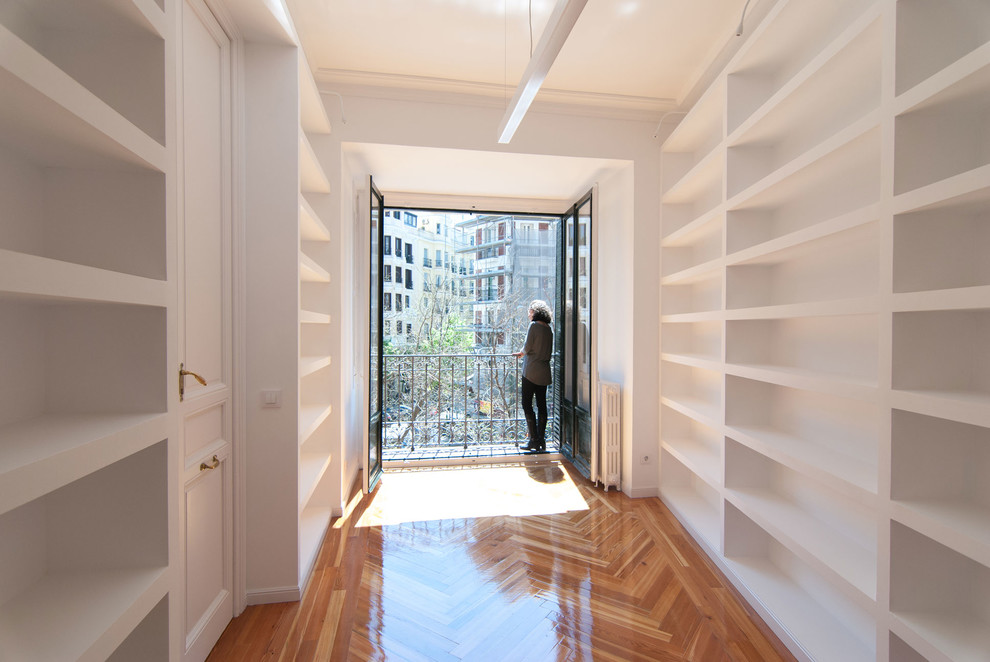 Idée de décoration pour un bureau tradition de taille moyenne avec une bibliothèque ou un coin lecture, un mur blanc, un sol en bois brun, un bureau indépendant et un sol marron.