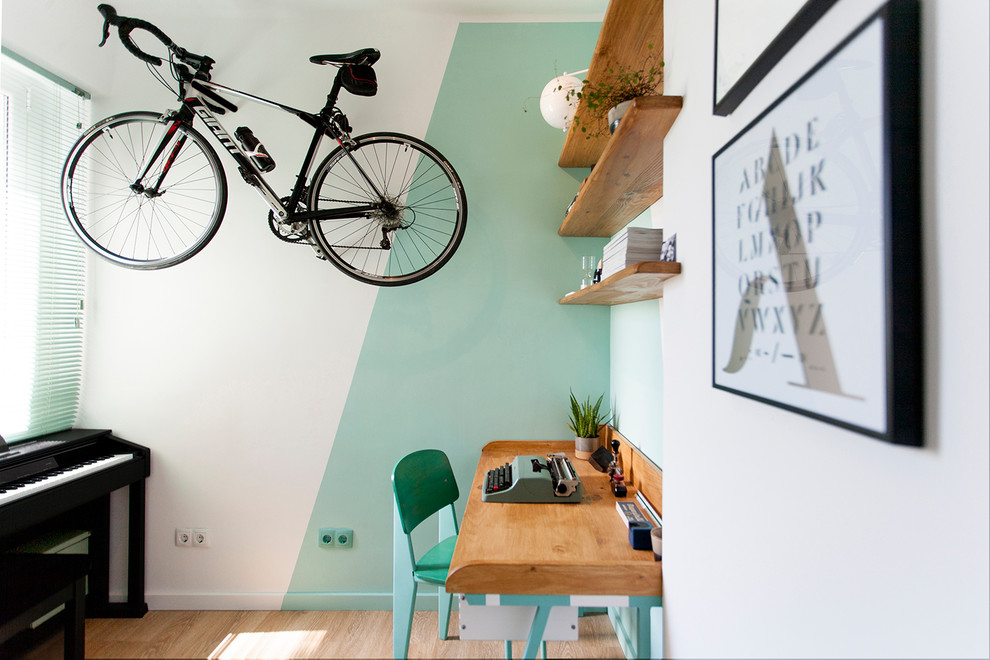 Cette photo montre un petit bureau tendance de type studio avec un mur vert, un bureau intégré, un sol marron et un sol en bois brun.