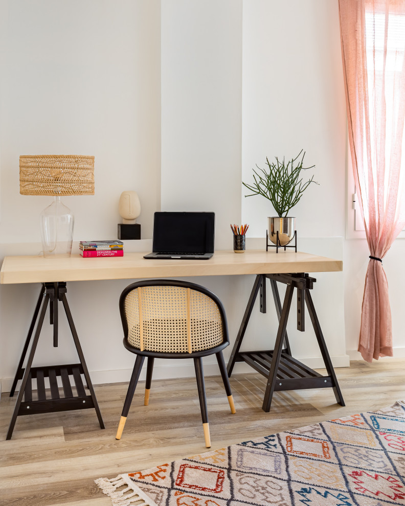 Imagen de despacho tropical con paredes blancas, suelo de madera clara, escritorio independiente y suelo beige