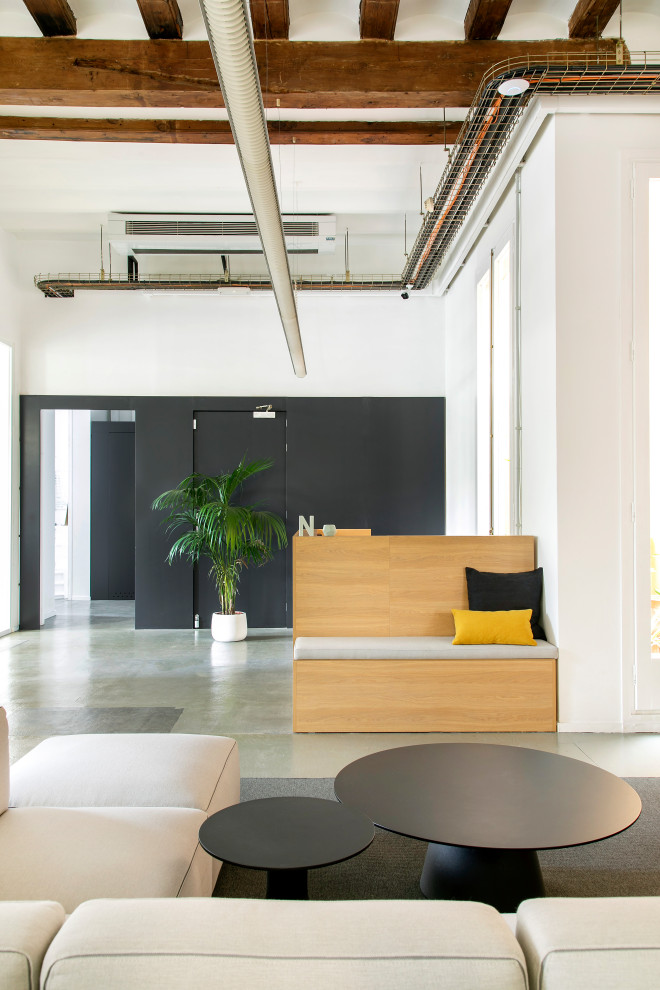 Aménagement d'un bureau moderne de taille moyenne avec un mur blanc, sol en béton ciré, un sol gris et un plafond voûté.