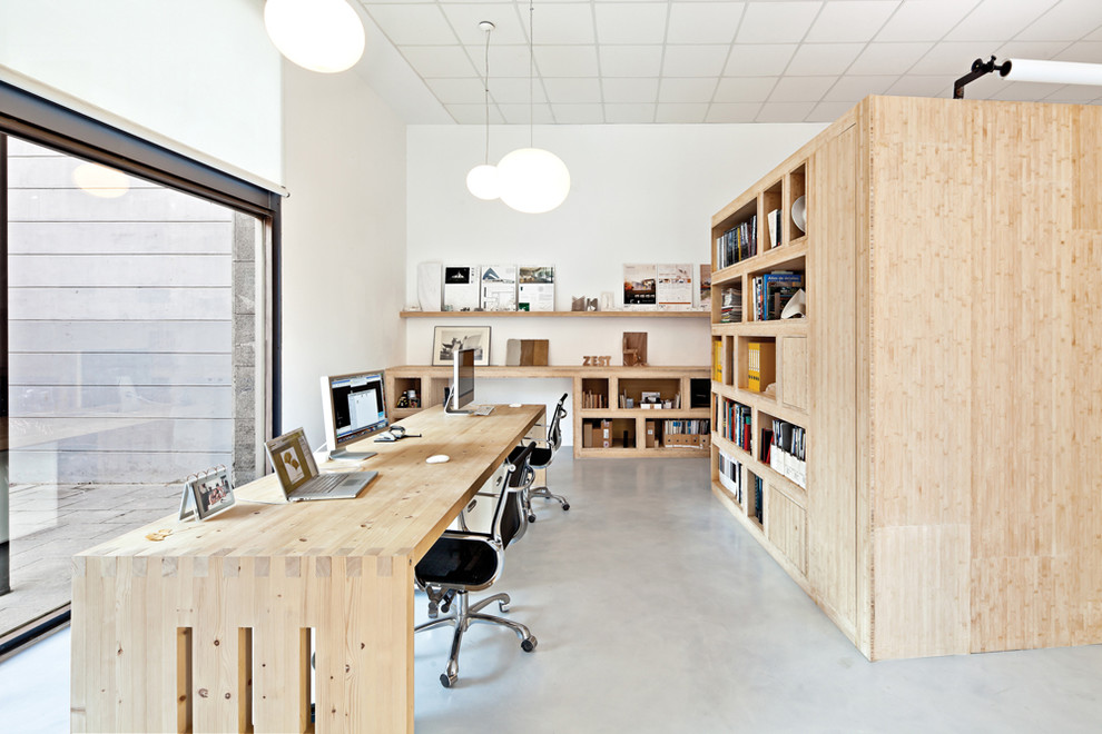 Exemple d'un grand bureau scandinave avec un mur blanc, sol en béton ciré, aucune cheminée et un bureau indépendant.