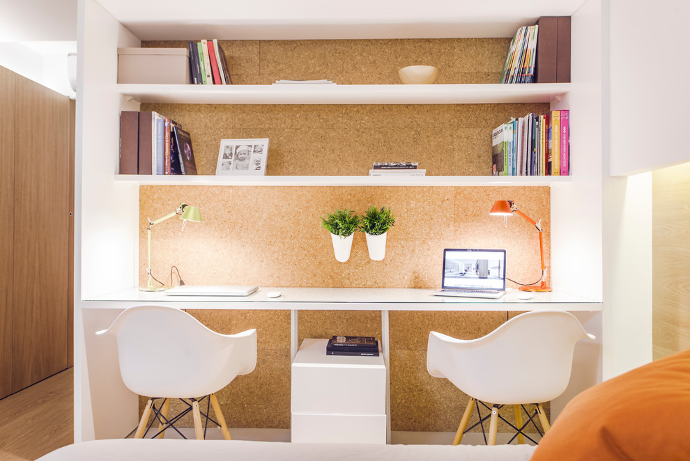 Kleines Skandinavisches Arbeitszimmer ohne Kamin mit Arbeitsplatz, brauner Wandfarbe, Einbau-Schreibtisch und hellem Holzboden in Valencia