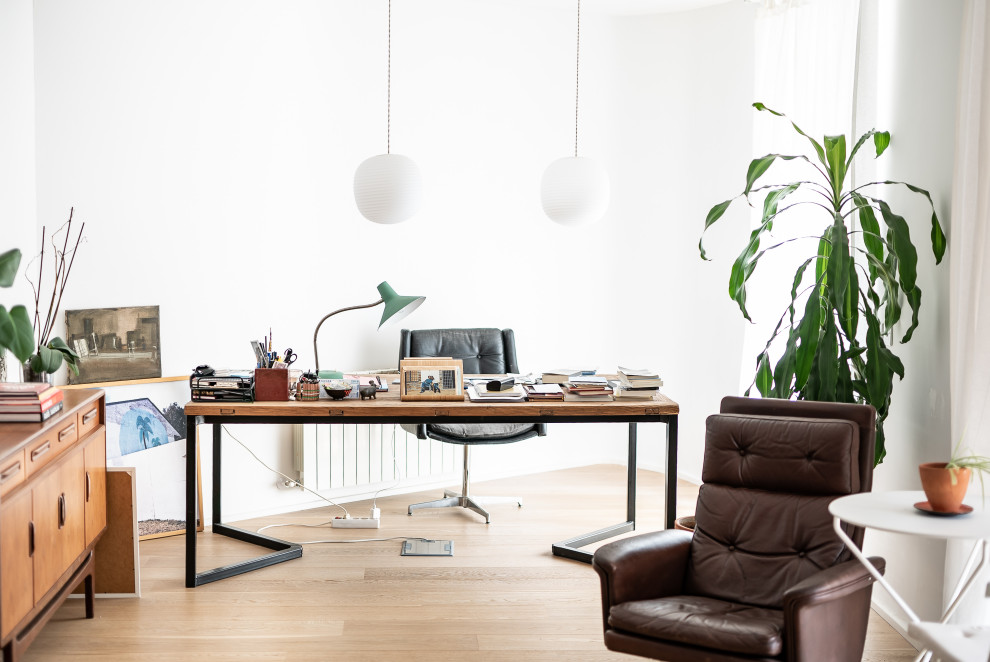 Imagen de despacho contemporáneo con paredes blancas, suelo de madera clara, escritorio independiente y suelo beige