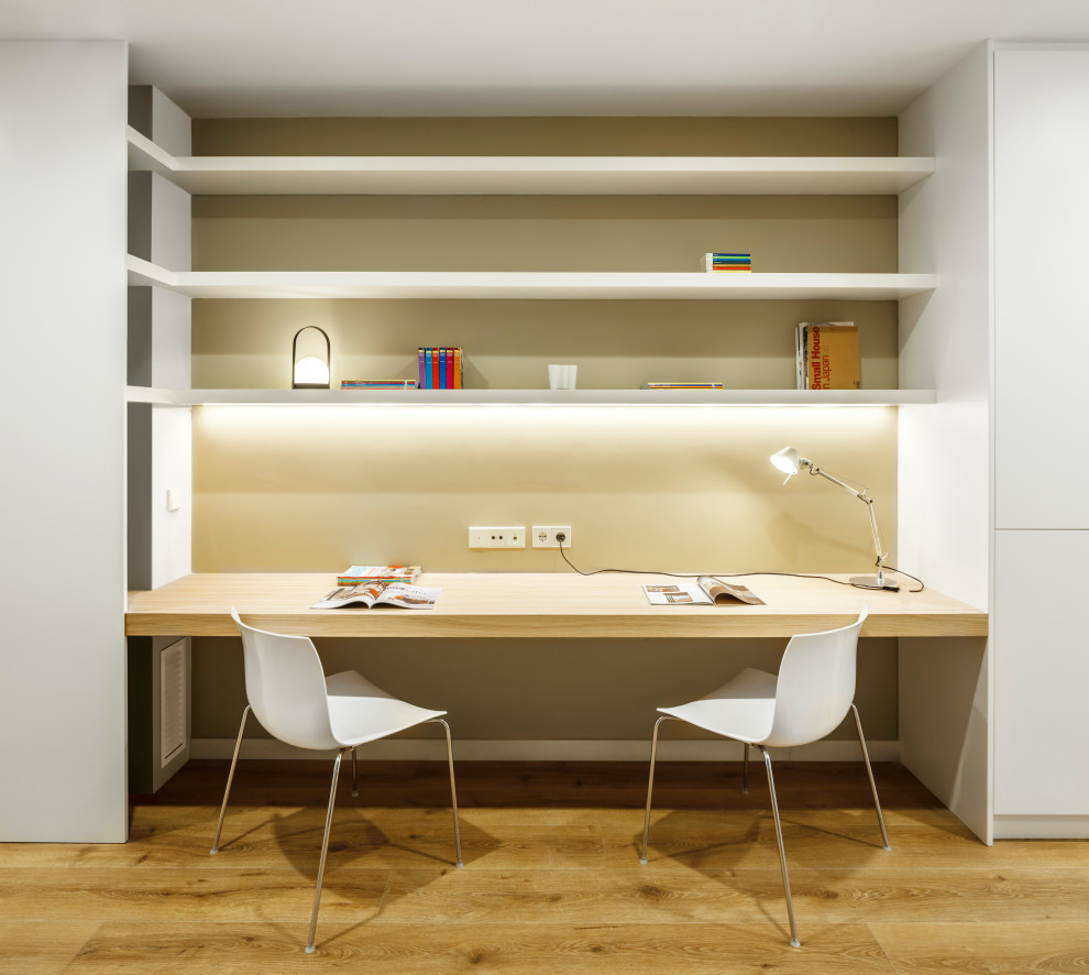 Ejemplo de despacho contemporáneo con paredes beige, suelo de madera en tonos medios, escritorio empotrado y suelo marrón